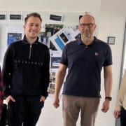 v. l. n. r.: Kati (2be), Roman (BFV), Stephan (Data Respons Solutions) und Dennis (BFV) vor der Markenwand bei Data Respons Solutions in Erlangen vor Ort.