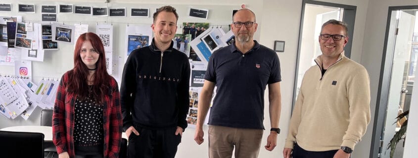 From left to right: Kati (2be), Roman (BFV), Stephan (Data Respons Solutions) and Dennis (BFV) in front of the brand wall at Data Respons Solutions in Erlangen.