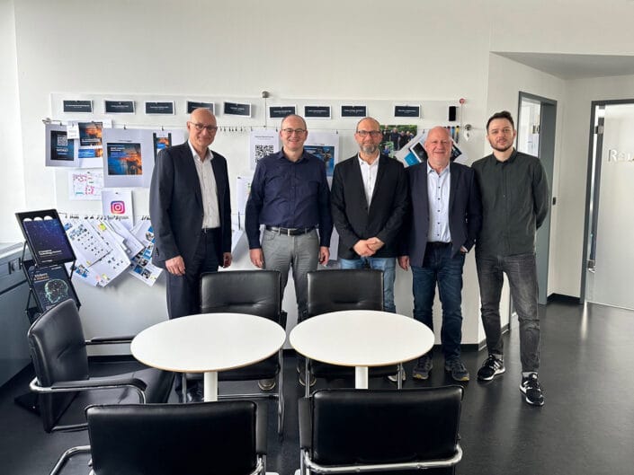 Ein Teil des Data Respons Solutions Teams mit der Bürgermeisterdelegation aus Erlangen vor der Markenwand